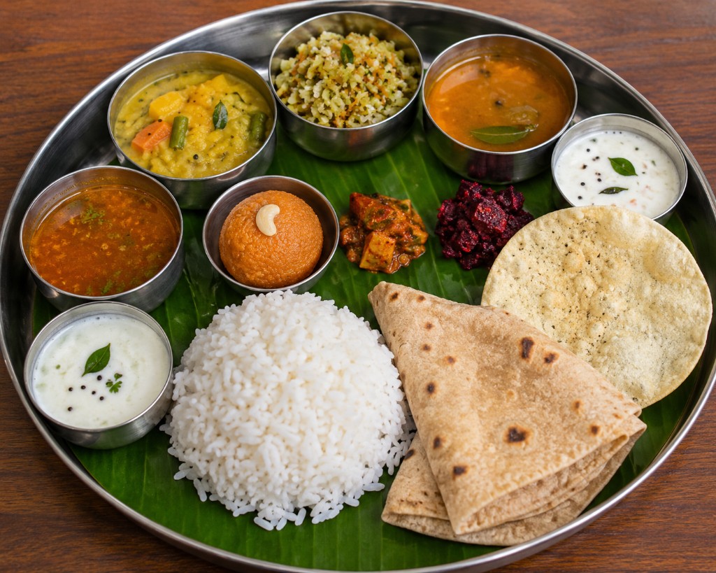 Traditional South Indian thali with curries, rice, and local vegetarian dishes on a banana leaf